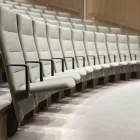 Arena stol med høy rygg og armlen i em buet auditoriesal Fora Form